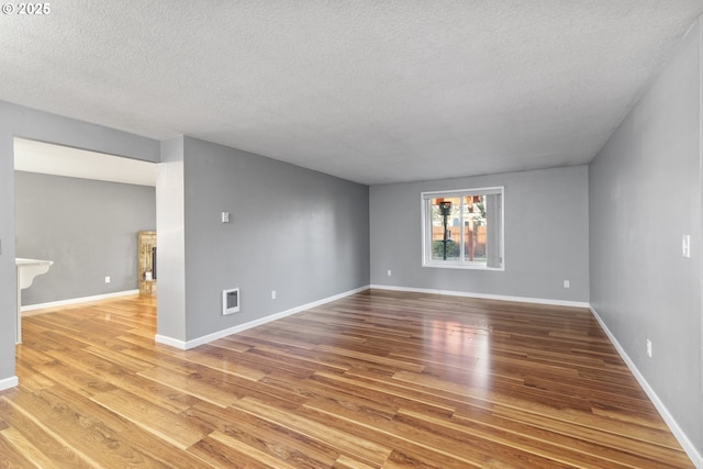 spare room featuring wood-type flooring and a textured ceiling