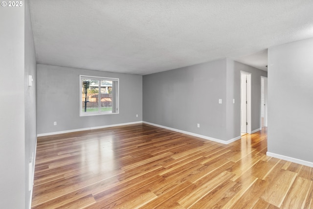 empty room featuring a textured ceiling and light wood-type flooring