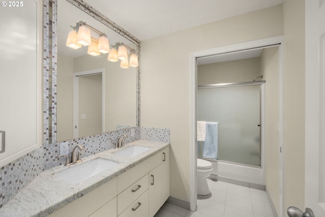 22767 SW Saunders Dr, Sherwood, OR 97140 - bathroom featuring toilet, double vanity, tile patterned floors, baseboards, and bath / shower combo with glass door
