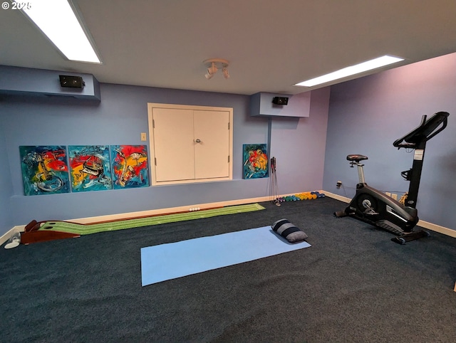 workout area with baseboards and carpet flooring