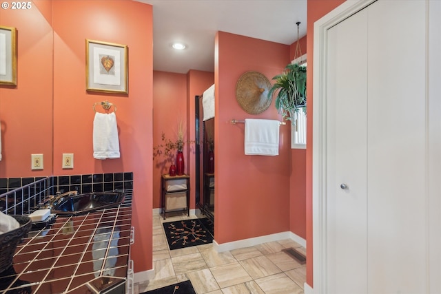 full bathroom with recessed lighting, baseboards, and a sink