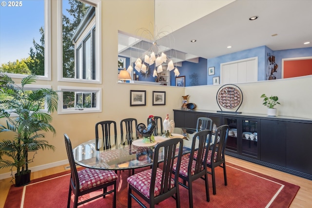 dining area with recessed lighting, baseboards, a notable chandelier, and wood finished floors