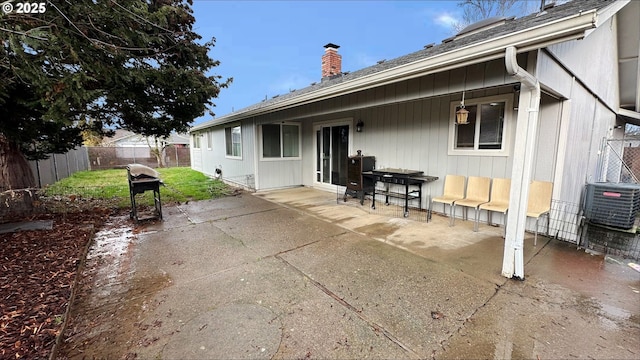 rear view of house featuring a chimney, a patio area, and a fenced backyard