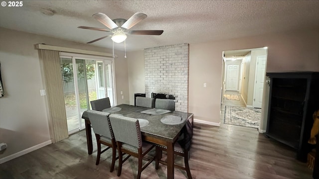 dining area with a ceiling fan, a textured ceiling, baseboards, and wood finished floors