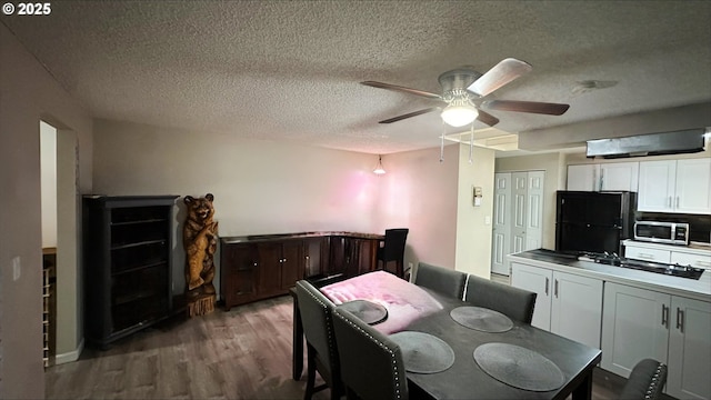 dining area with a textured ceiling, wood finished floors, and a ceiling fan