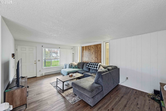 1030 Augustine Ave, Coos Bay, OR 97420 - living area with a textured ceiling, a baseboard radiator, wooden walls, and dark wood-style floors