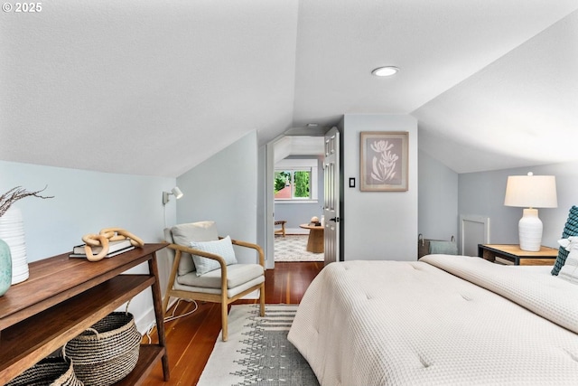 bedroom featuring wood finished floors and vaulted ceiling