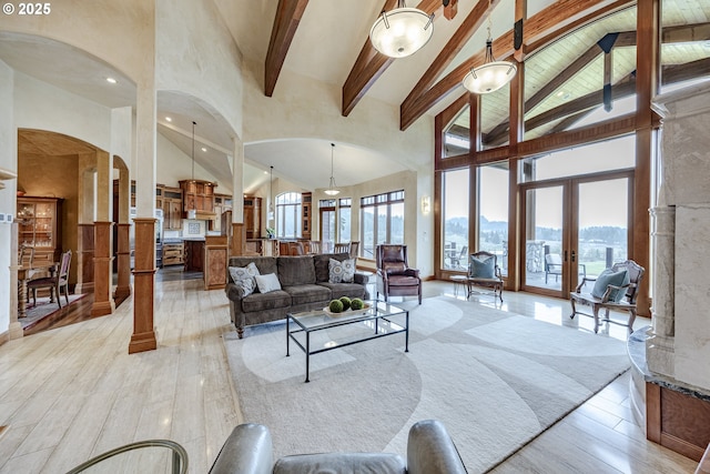 living room with high vaulted ceiling, light wood-type flooring, beam ceiling, and a mountain view