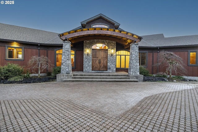 exterior entry at dusk with stone siding