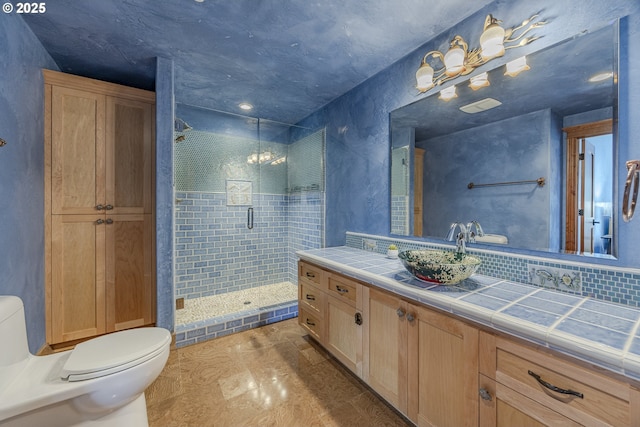 full bathroom featuring vanity, backsplash, a shower stall, and toilet