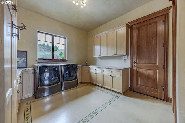 washroom with a sink, cabinet space, and washer and dryer