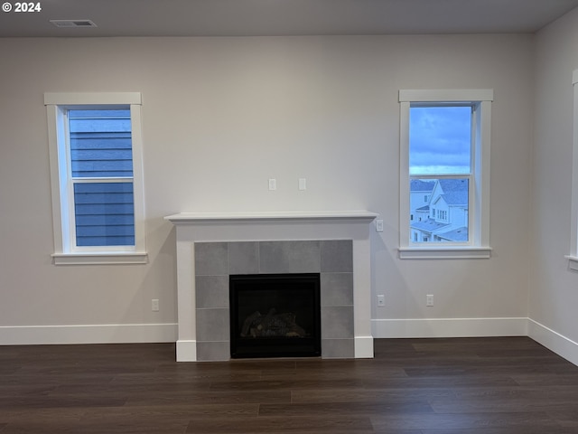 details with a tile fireplace, baseboards, and wood finished floors