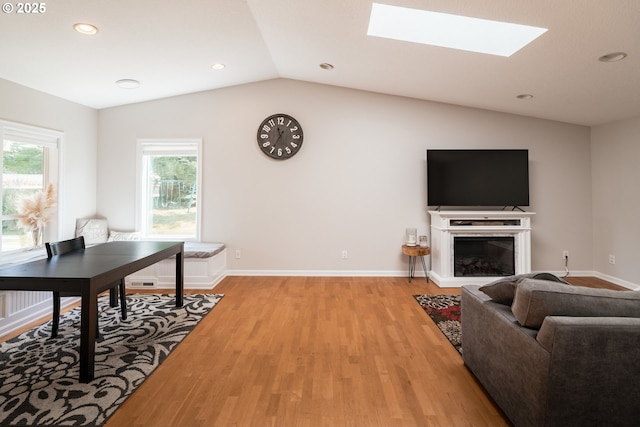 14424 SE Bevington Ct, Milwaukie, OR 97267 - living room featuring light wood finished floors, vaulted ceiling, a skylight, a glass covered fireplace, and recessed lighting