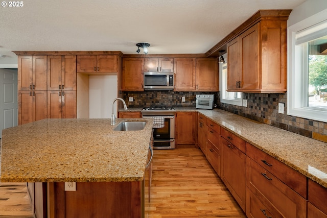 14424 SE Bevington Ct, Milwaukie, OR 97267 - kitchen featuring stainless steel appliances, light wood-style flooring, brown cabinets, and backsplash