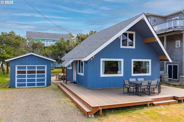 33565 Shore Dr, Pacific City, OR 97135 - back of property featuring outdoor dining space, a wooden deck, an outbuilding, roof with shingles, and a garage