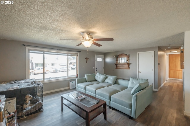 living area featuring baseboards, a textured ceiling, a ceiling fan, and wood finished floors