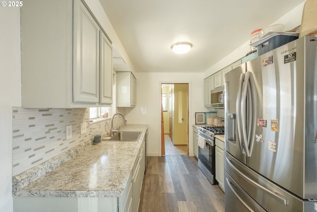 kitchen featuring backsplash, stainless steel appliances, a sink, and light countertops