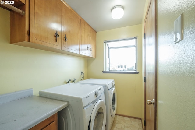 clothes washing area with separate washer and dryer, cabinet space, and baseboards