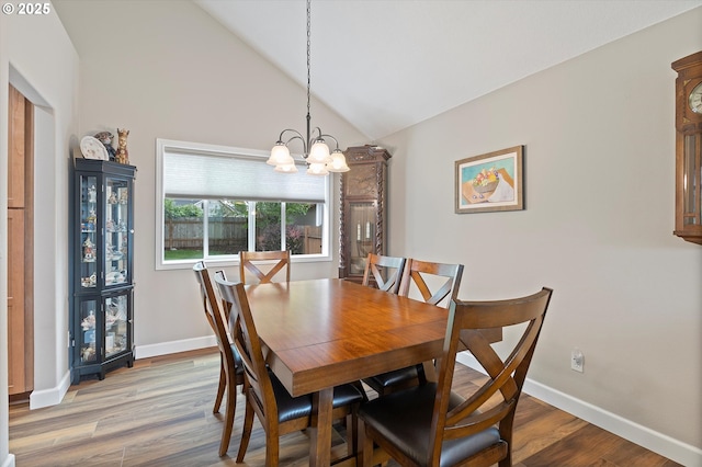 14644 SE Sterling Ct, Clackamas, OR 97015 - dining area with a chandelier, vaulted ceiling, wood finished floors, and baseboards