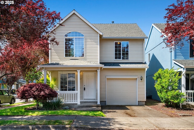 traditional home with roof with shingles, an attached garage, a porch, and driveway