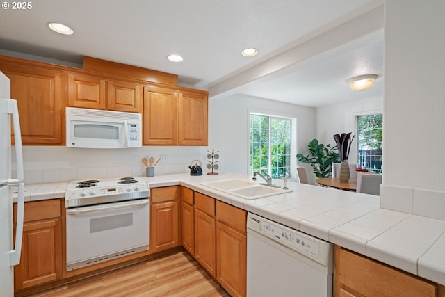 kitchen featuring white appliances, recessed lighting, a sink, and light wood-style flooring