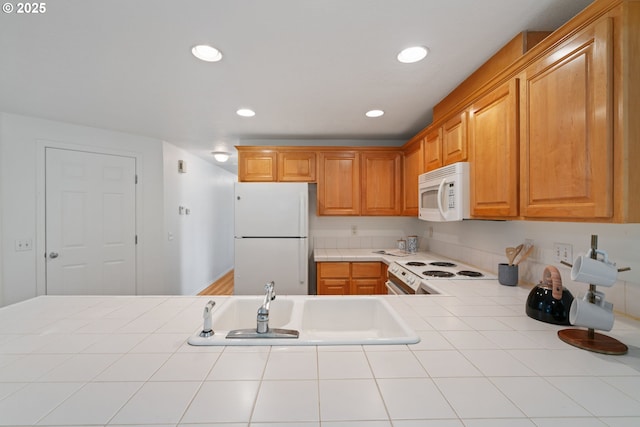 kitchen with white appliances, tile countertops, recessed lighting, and a sink