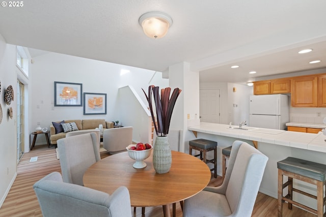dining area featuring recessed lighting, baseboards, and light wood-type flooring