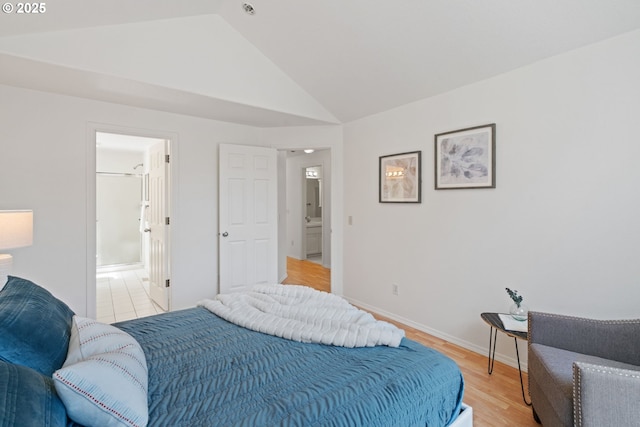 bedroom featuring baseboards, light wood-style flooring, and lofted ceiling