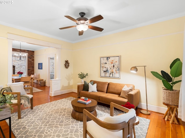 2127 NW Irving St Unit 104, Portland, OR 97210 - living area with ornamental molding, light wood-style floors, a ceiling fan, baseboards, and a chandelier
