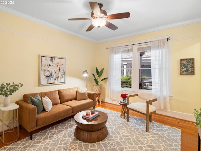 2127 NW Irving St Unit 104, Portland, OR 97210 - living area with wood finished floors, crown molding, a ceiling fan, and baseboards