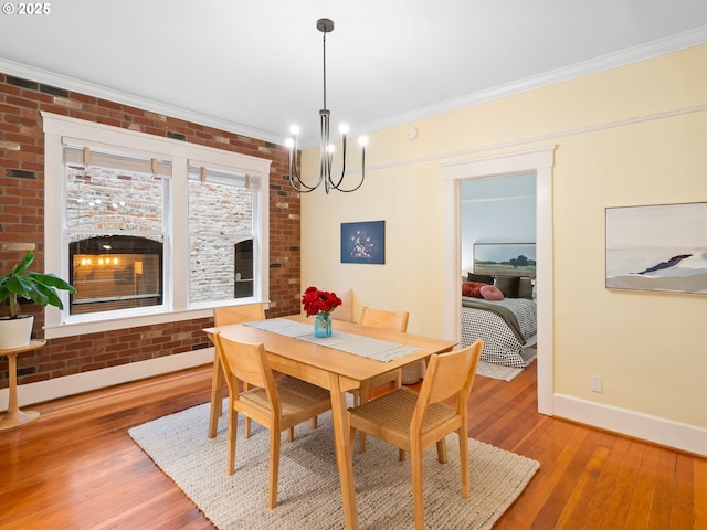 2127 NW Irving St Unit 104, Portland, OR 97210 - dining room with a chandelier, light wood-style floors, baseboards, a fireplace, and ornamental molding