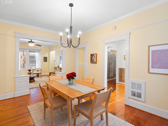 2127 NW Irving St Unit 104, Portland, OR 97210 - dining space featuring wood finished floors, ornamental molding, baseboards, ornate columns, and a chandelier