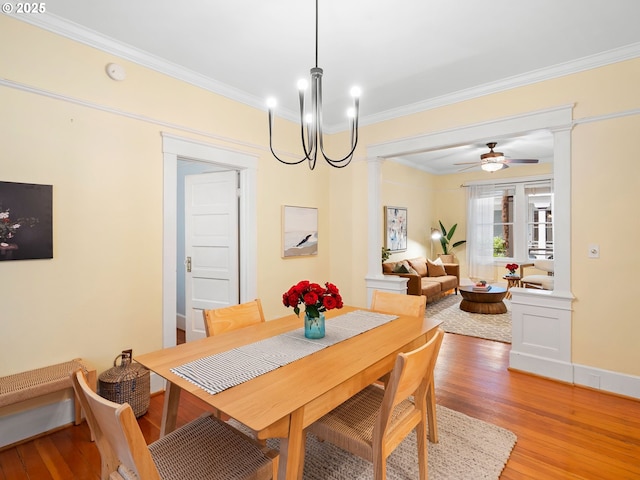 2127 NW Irving St Unit 104, Portland, OR 97210 - dining space with decorative columns, crown molding, light wood finished floors, and ceiling fan