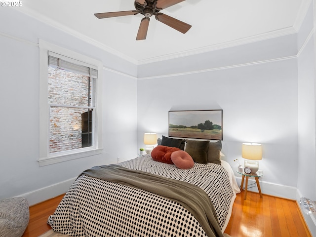 2127 NW Irving St Unit 104, Portland, OR 97210 - bedroom featuring wood finished floors, baseboards, crown molding, and a ceiling fan