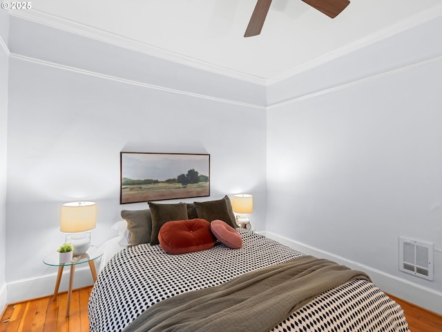 2127 NW Irving St Unit 104, Portland, OR 97210 - bedroom featuring crown molding, baseboards, wood finished floors, and a ceiling fan