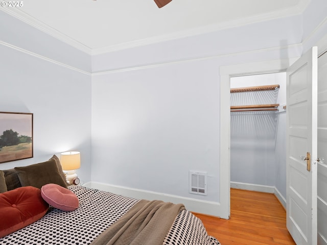 2127 NW Irving St Unit 104, Portland, OR 97210 - bedroom with crown molding, a closet, light wood-style flooring, baseboards, and ceiling fan