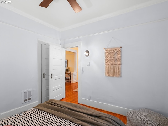 2127 NW Irving St Unit 104, Portland, OR 97210 - bedroom with baseboards, crown molding, ceiling fan, and wood finished floors