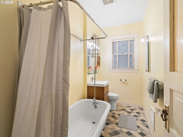 2127 NW Irving St Unit 104, Portland, OR 97210 - bathroom featuring a freestanding tub, toilet, tile patterned floors, baseboards, and vanity