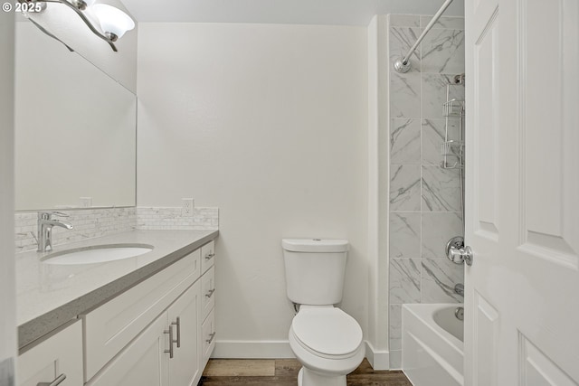 full bath featuring vanity, baseboards, toilet, wood finished floors, and shower / washtub combination