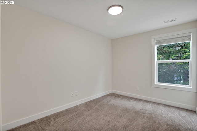 carpeted empty room featuring baseboards