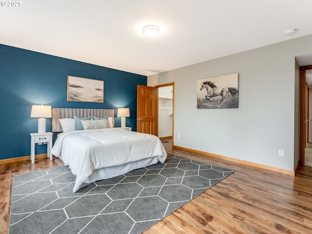 bedroom with dark wood-type flooring, a spacious closet, and a closet