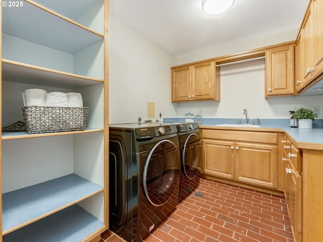 laundry area with sink, washing machine and dryer, and cabinets