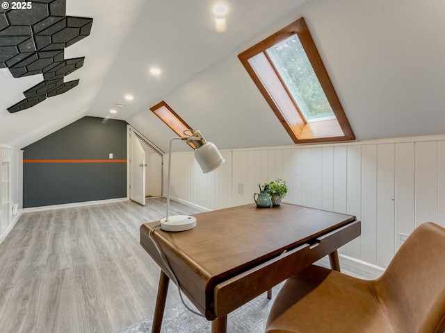 office area featuring light wood-type flooring and lofted ceiling with skylight