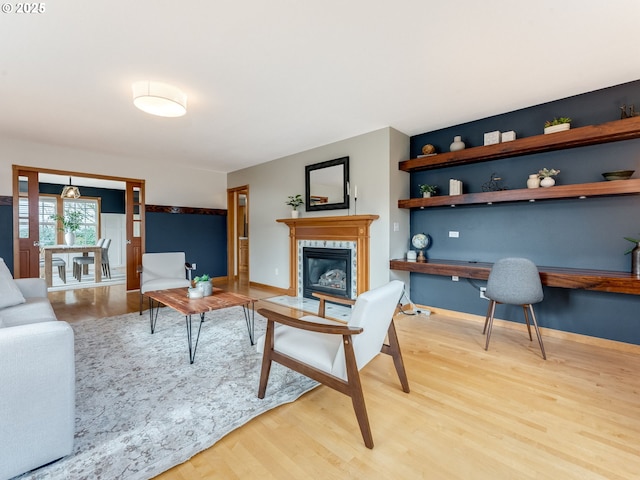 living room with a tiled fireplace and hardwood / wood-style floors