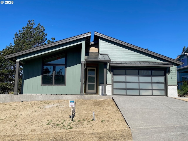 559 Meadows Dr, Manzanita, OR 97130 - view of front of home with an attached garage, driveway, a standing seam roof, metal roof, and brick siding