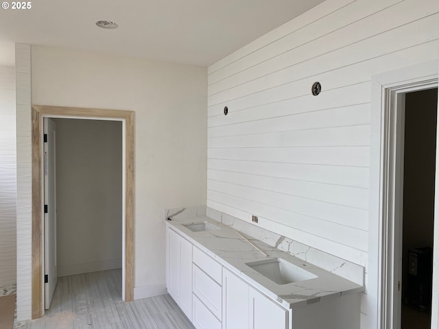 559 Meadows Dr, Manzanita, OR 97130 - kitchen with a sink, white cabinets, light wood finished floors, baseboards, and light stone countertops