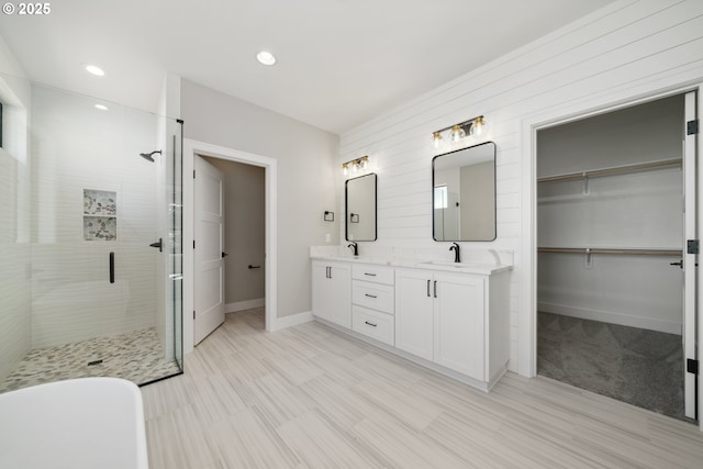 559 Meadows Dr, Manzanita, OR 97130 - full bath with a stall shower, double vanity, baseboards, a walk in closet, and recessed lighting