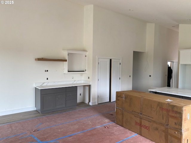 559 Meadows Dr, Manzanita, OR 97130 - kitchen with a high ceiling, light countertops, baseboards, and gray cabinetry