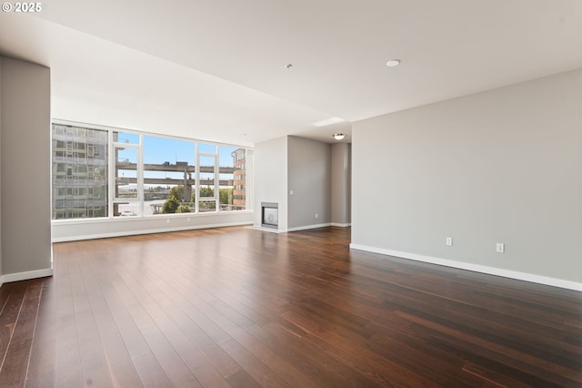 1930 S River Dr Unit W504, Portland, OR 97201 - spare room featuring baseboards, dark wood-type flooring, and a glass covered fireplace
