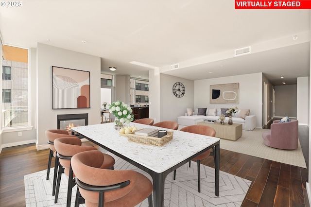 1930 S River Dr Unit W504, Portland, OR 97201 - dining space featuring dark wood-type flooring, a glass covered fireplace, and baseboards